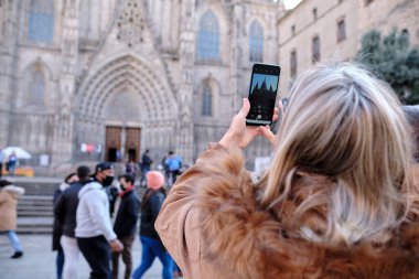 Barselona, İspanya - 10 Aralık 2021: Bir turist Barselona Katedrali 'nin fotoğrafını çekmek için cep telefonu kullanıyor