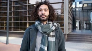 Yakışıklı genç hippi iş bölgesinde kameraya bakıyor.