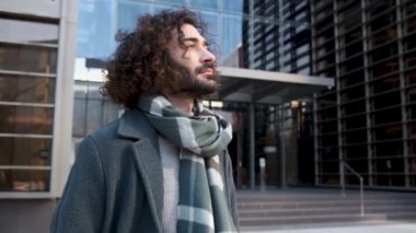 Zarif gündelik giysiler içindeki iş adamı finans bölgesinde destansı bir poz veriyor.