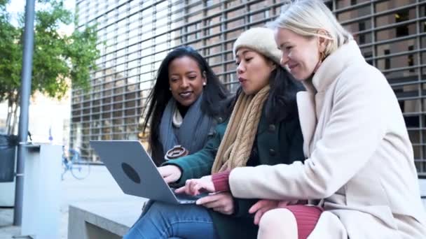 Іспаномовні, азіатські та кавказькі бізнес-леді використовують ноутбук на відкритому повітрі у діловій зустрічі — стокове відео