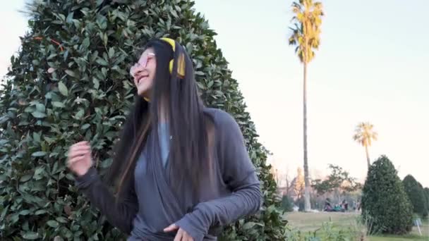 Heureuse femme asiatique s'amuser tout en écoutant de la musique et en dansant en plein air dans la rue de la ville. — Video