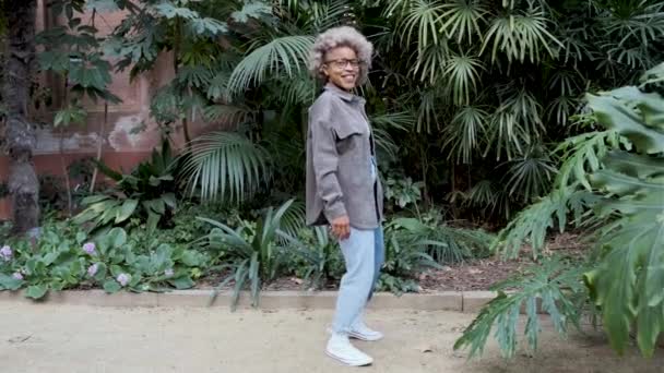 Afro mulher latina se divertindo enquanto dança feliz em um jardim natural. — Vídeo de Stock