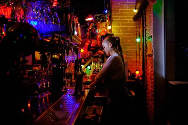 계산대 뒤에서 서서 바나 술집에서 일하는 고객에게 주문을 준비하는 여성 바텐더. — 스톡 사진