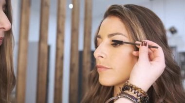 Kadın güzellik salonundaki düğün için saçını ve makyajını yaptırıyor..