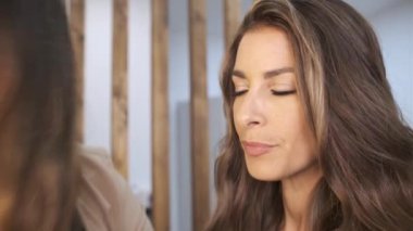 Profesyonel makyöz, müşterisi için güzellik salonunda düğün günü makyaj yapıyor..