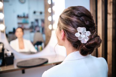 Kuaförde saç stili ve şık aksesuarları olan bir kadın görüyorum..