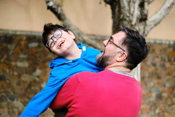 Loving father holding and playing with his disabled son while enjoying time together outdoors. —  Fotos de Stock