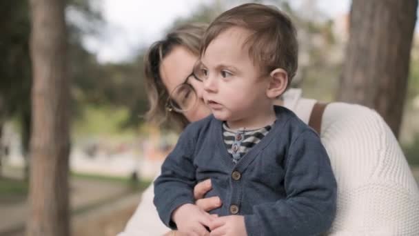 Mamma felice che gioca con il suo piccolo figlio mentre si godono la giornata all'aperto in un parco insieme. — Video Stock