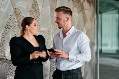 İş arkadaşları ofis binasının dışında konuşuyor..