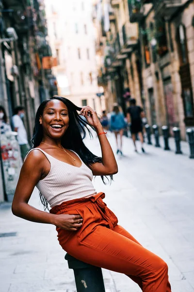 Gülümseyen Afrikalı Amerikalı kadın şehir sokaklarında poz verirken kameraya bakıyor..