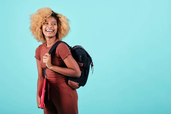 Happy afro student looking away and smiling while standing on an isolated background. Education concept.
