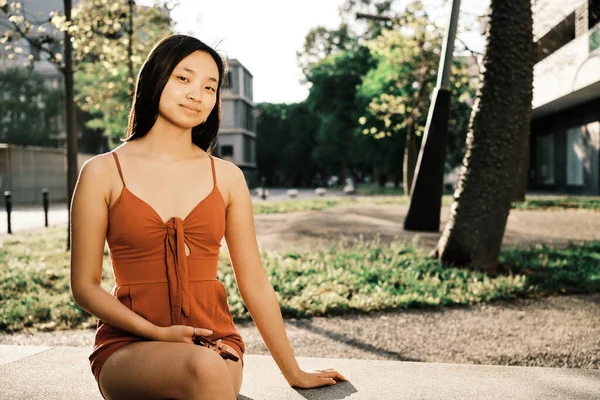 Расслабленная Молодая Азиатка Смотрит Камеру Сидя Скамейке Городском Парке — стоковое фото