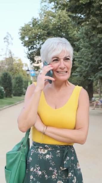 Parkta Yürürken Telefonda Konuşan Gri Saçlı Olgun Bir Kadın Teknoloji — Stok video