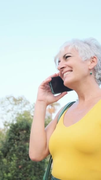 Beyaz Saçlı Olgun Bir Kadın Parkta Dikilirken Telefonla Konuşuyor Teknoloji — Stok video