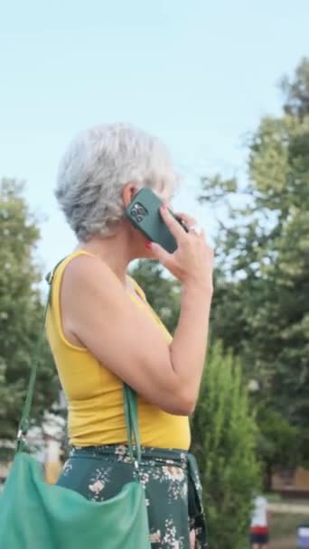Parkta Dışarıda Dikilirken Telefonda Konuşan Gri Saçlı Olgun Bir Kadın — Stok video