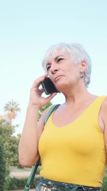 Dışarıda Telefonla Konuşurken Gülümseyen Gri Saçlı Olgun Bir Kadın Teknoloji — Stok video