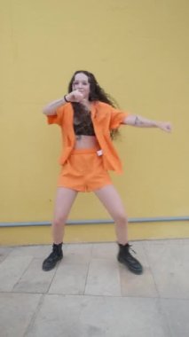 Genç bayan dansçı sokakta hip hop dansı yapıyor. Müzik ve dans konsepti.