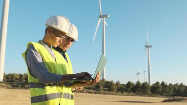 Two Engineers Using Laptop While Working Together Wind Turbine Field — Vídeos de Stock