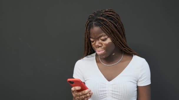African American Young Woman Vitiligo Smiling While Using Mobile Phone — Vídeo de Stock