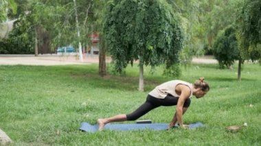 Parktaki bir paspasın üzerinde yoga yapan bir adam. Spor ve sağlıklı yaşam tarzı konsepti.