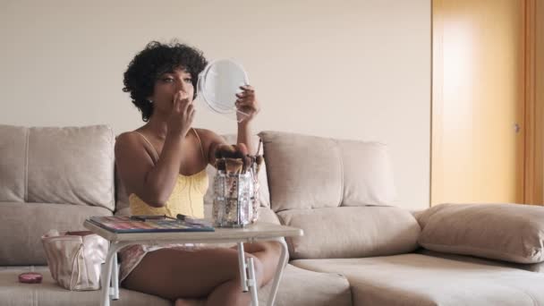 Διεμφυλική Γυναίκα Κρατώντας Και Κοιτάζοντας Ένα Μικρό Καθρέφτη Ενώ Εφαρμογή — Αρχείο Βίντεο