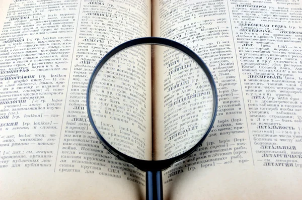 Revealling book with magnifying glass — Stock Photo, Image