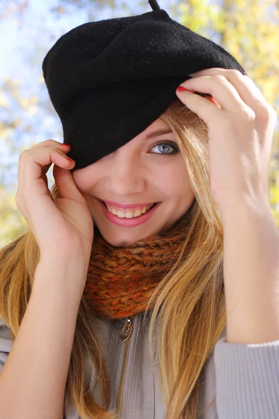 Leende flicka i en hatt som gömmer sig öga — Stockfoto