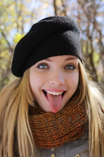 Portrait of young girl shows off her tongue — Stock Photo, Image