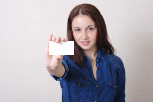Young woman in jeans with blank card — Stock Photo, Image
