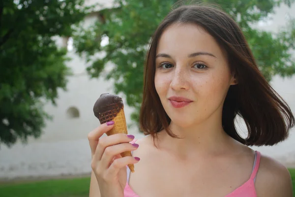 Young woman standing in the park with ice crem — Stock Photo, Image