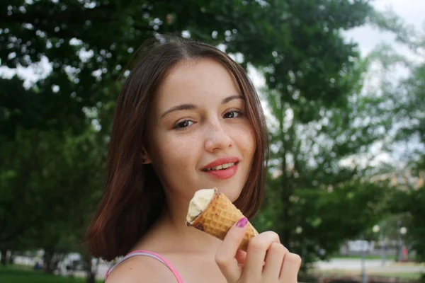 Young woman standing in the park with ice crem — Stock Photo, Image