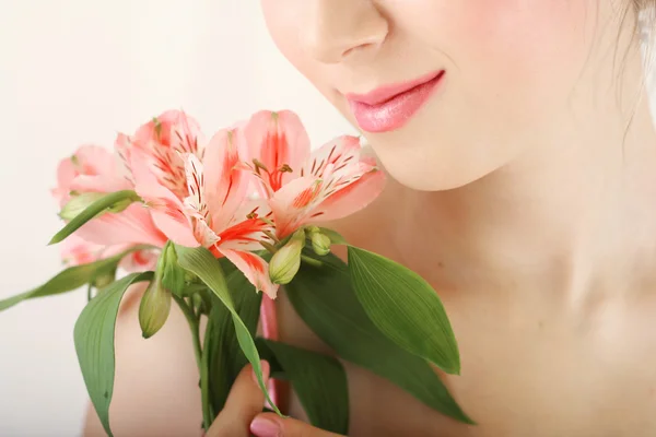 Closeup portrait of young woman touching pink tender lily — Stock Photo, Image