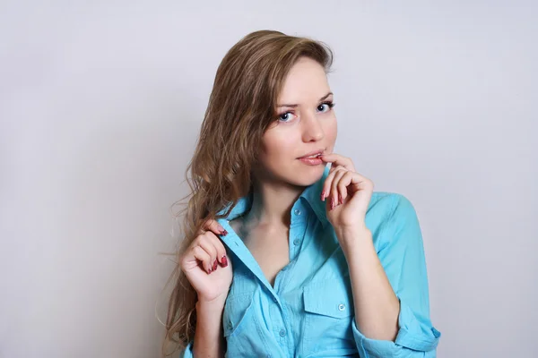 Gorgeous smiling  woman with blue eyes finger on her lips studio — Stock Photo, Image