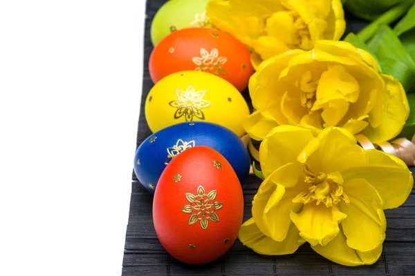 Пасхальные яйца с желтыми тюльпанами — стоковое фото
