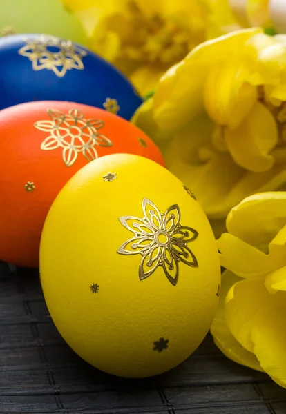 Пасхальные яйца с желтыми тюльпанами — стоковое фото