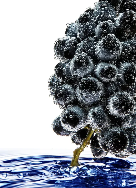 Ramo de uvas flotando en el agua con burbujas de aire —  Fotos de Stock