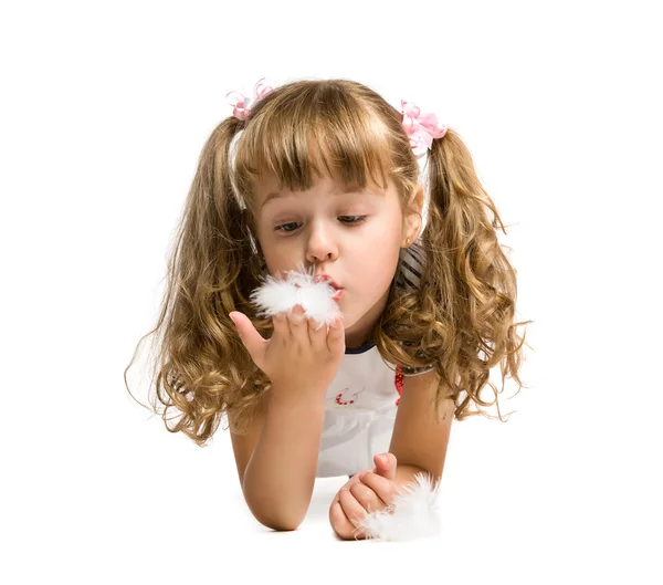 Niña soplando en una pluma — Foto de Stock