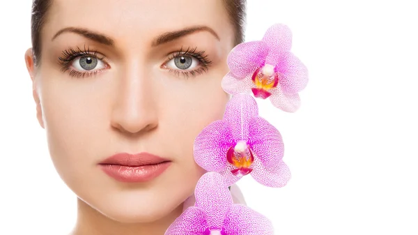Vacker kvinna och orkidé blommor — Stockfoto