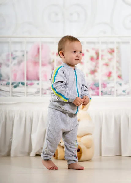 Kleine jongen in de buurt van het bed — Stockfoto