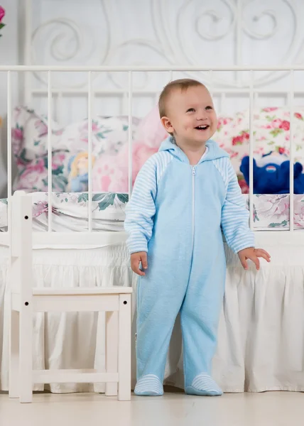 Kleine jongen in de buurt van het bed — Stockfoto