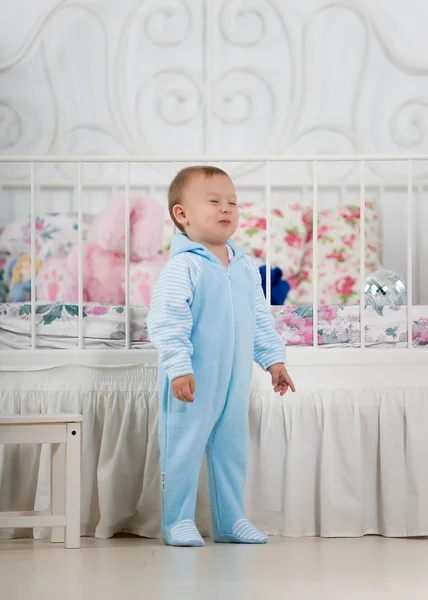 Kleine jongen in de buurt van het bed — Stockfoto