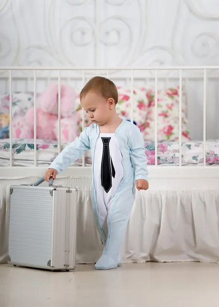 Малыш стоит с чемоданом — стоковое фото
