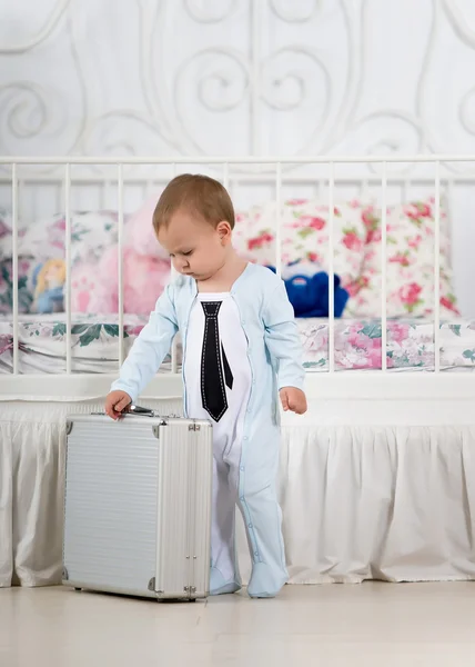 Bambino sta in piedi con una valigia — Foto Stock