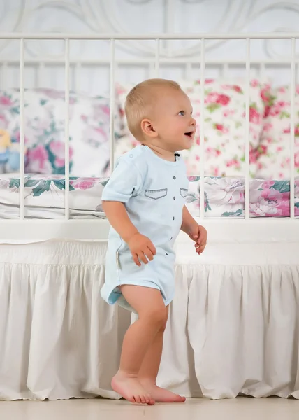 Kleine jongen in de buurt van het bed — Stockfoto