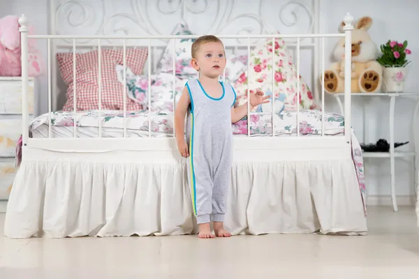 Маленький мальчик рядом с кроватью — стоковое фото