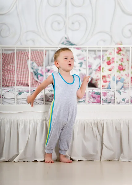 Kleine jongen in de buurt van het bed — Stockfoto