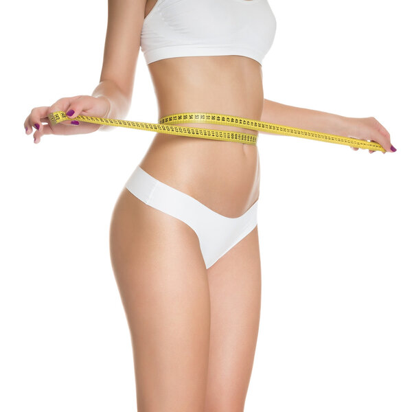 Женщина, измеряющая идеальную форму красивой тонированной талии, здоровой изолированной на белом фоне. Идеальное стройное тело. Диета
