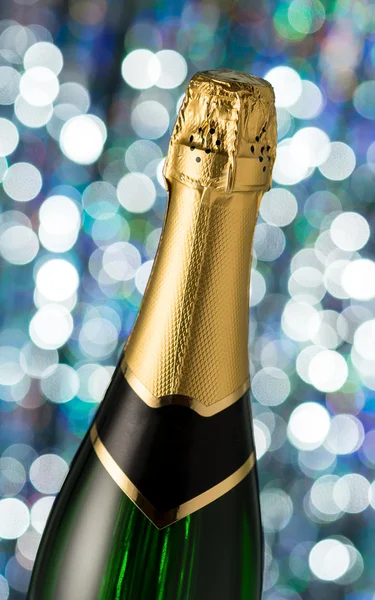 Glasses and bottle of champagne, serpentine isolated on a holiday bokeh background. — Stock Photo, Image
