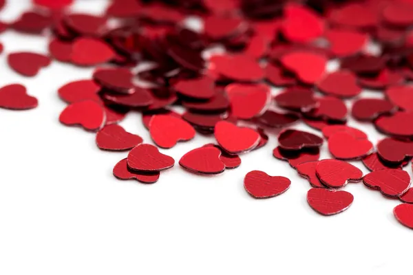 Valentines decoratie van rode confetti hart tegen witte achtergrond met bokeh — Stockfoto