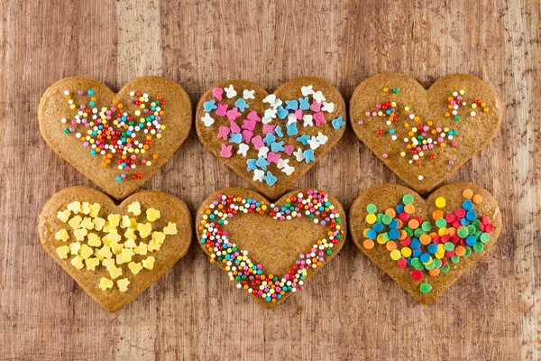 Bolinhos em forma de coração em forma de valentine em uma placa de madeira — Fotografia de Stock